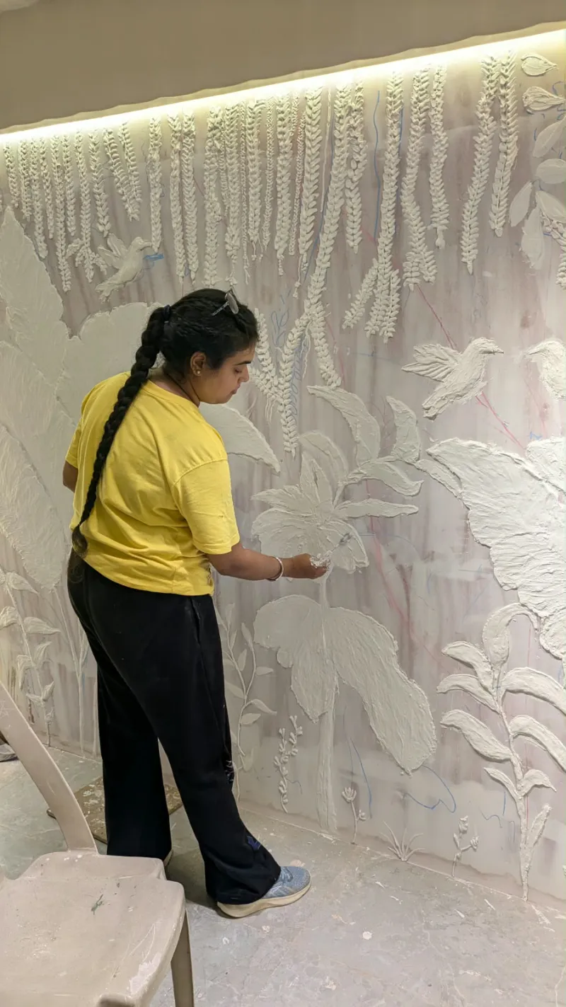 Hand-sculpted white plaster florals on a backlit feature wall