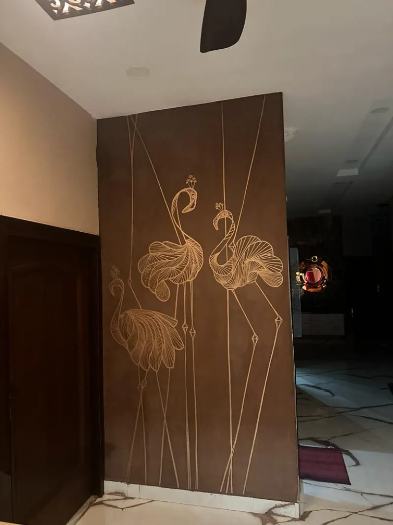 Gold single-line flamingos on a deep brown wall