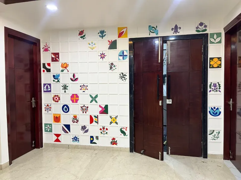 Grid of hand-painted Indian motifs on a geometric wall